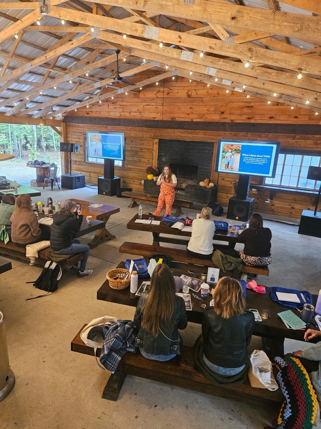 Marisa Grover teaching a room of short-term rental operators at a live event in a wooden pavilion