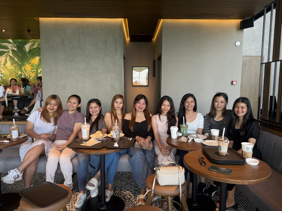 A dozen SimplyVA virtual assistants smiling together at a café meetup